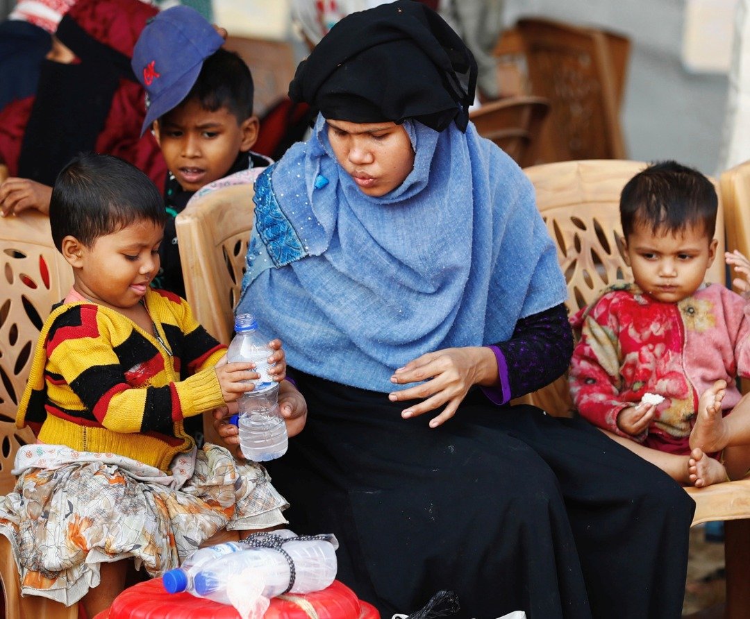 一名罗兴亚妇女与其孩子于周五，在帐篷内等待登船前往安置地。有难民组织批评孟国政府，指转移行动是对难民们的大规模拘留，违反了人权义务。