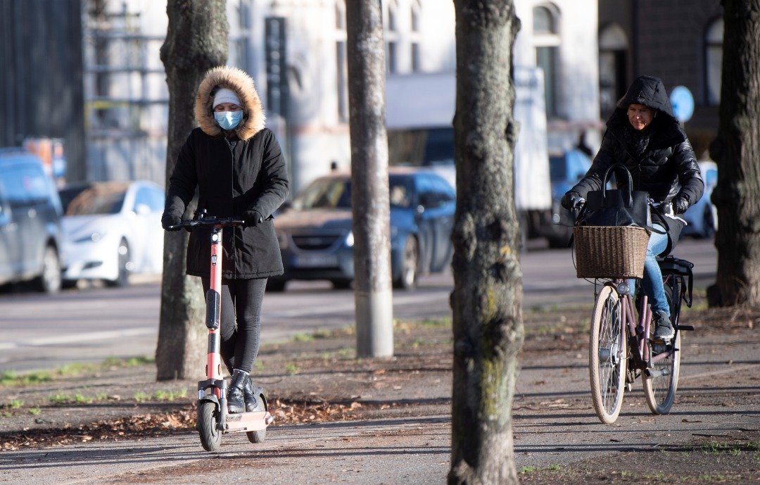 瑞典当局此前未提出戴口罩的建议，但街上可见到有民众骑车外出已戴上口罩，做好防疫措施。（图取自路透社）