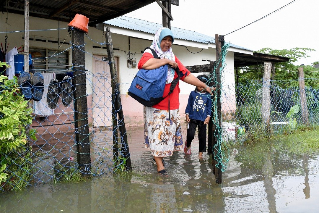 甘马士53岁灾黎诺丽詹收拾细软前往临时疏散中心。