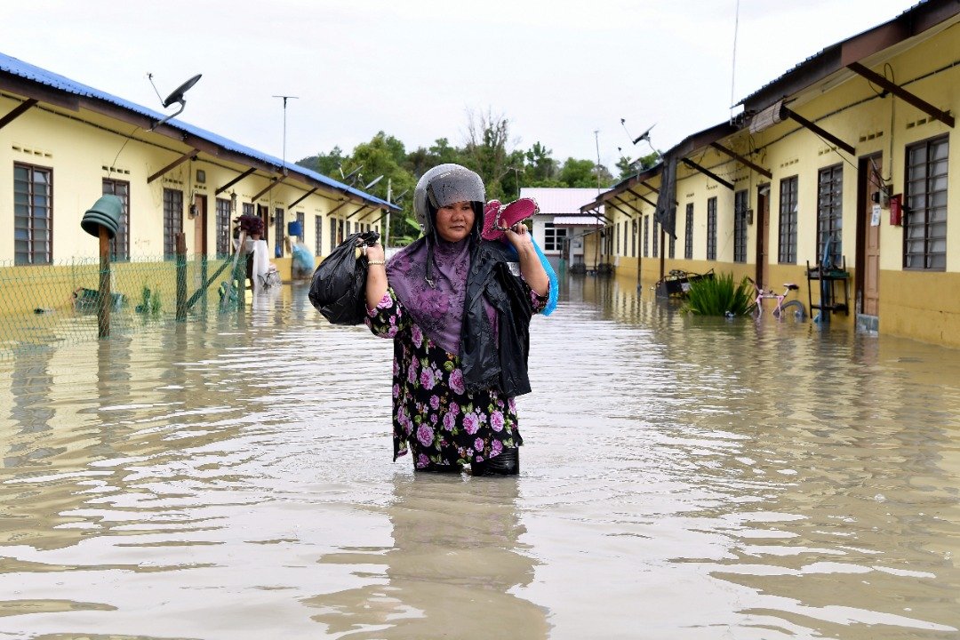 46岁扎希雅亚雅高举日用品涉水走出灾区。