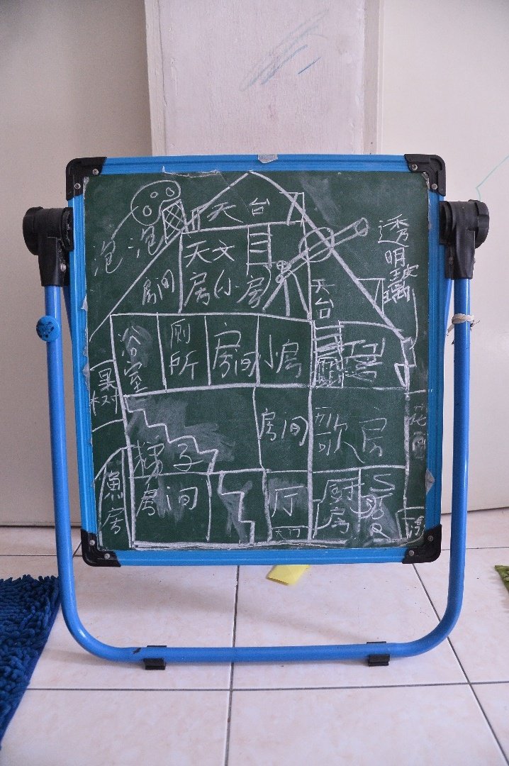 9岁儿子画出心里的梦想家园，希望有朝一日能够如愿，与家人一起迁入梦想家园同住。（摄影：曾钲勤）