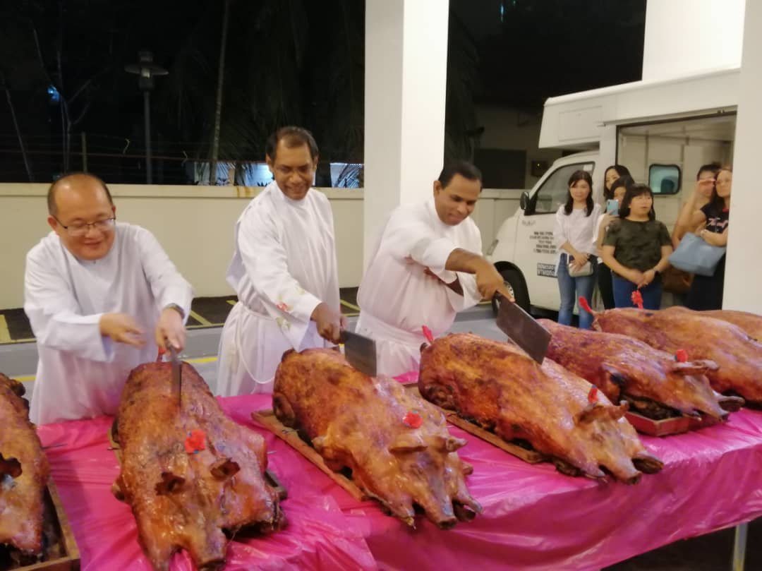 由神父们操刀，切烧猪与天主教徒们共享美味的烧肉。