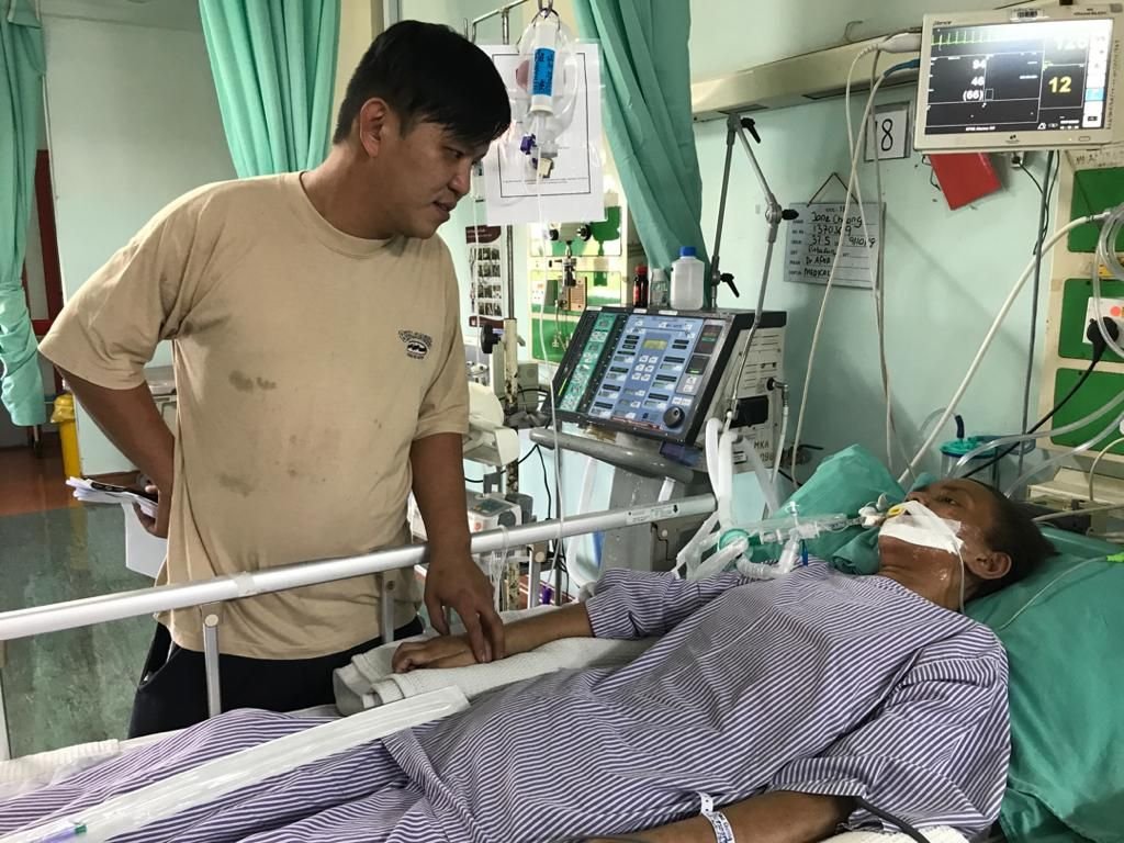 郑贵豪（左）几乎每天来回中央医院照顾卧病在床的张燕怡。