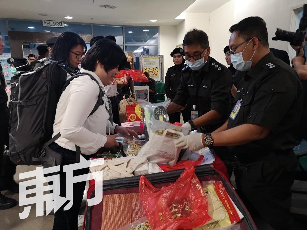 机场检疫及检验局官员对每个可疑行李箱进行检验，避免猪肉等产品流入我国，并可能造成非洲猪瘟或其他疾病的爆发。（摄影：吴维康）