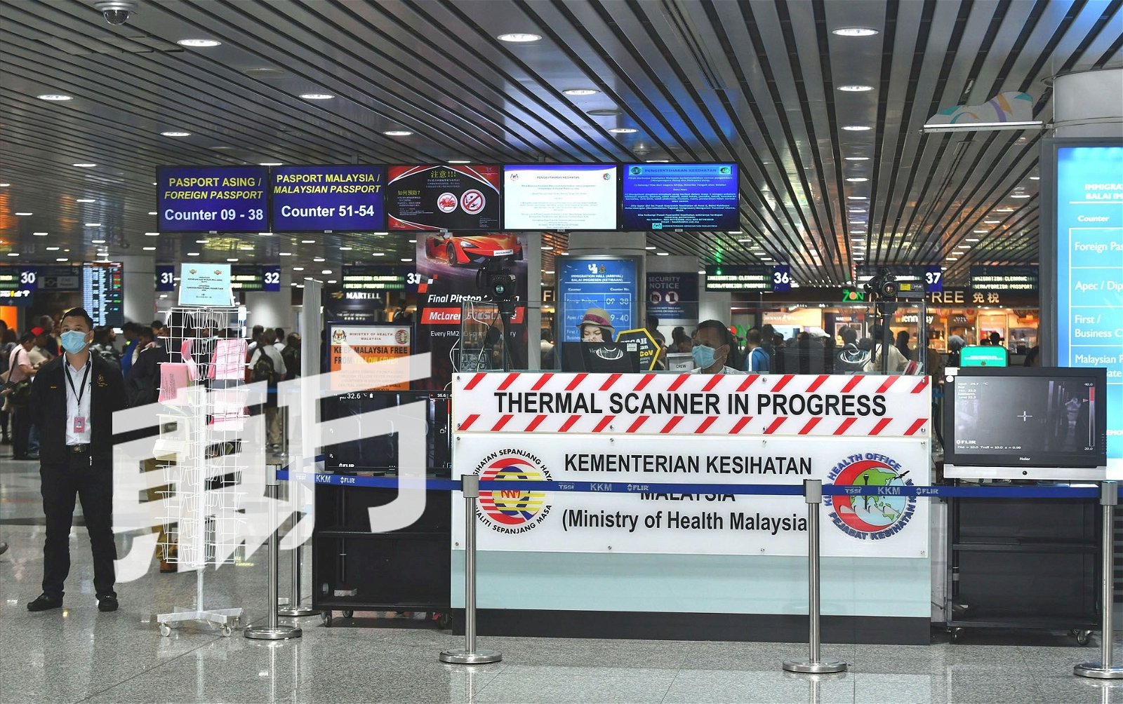 卫生部分别在吉隆坡国际机场和吉隆坡第二国际机场，设有最新颖的体温扫描器，并24小时探测每位入境我国旅客的体温，严禁把关。图为戴著口罩的卫生人员在检疫处值勤。