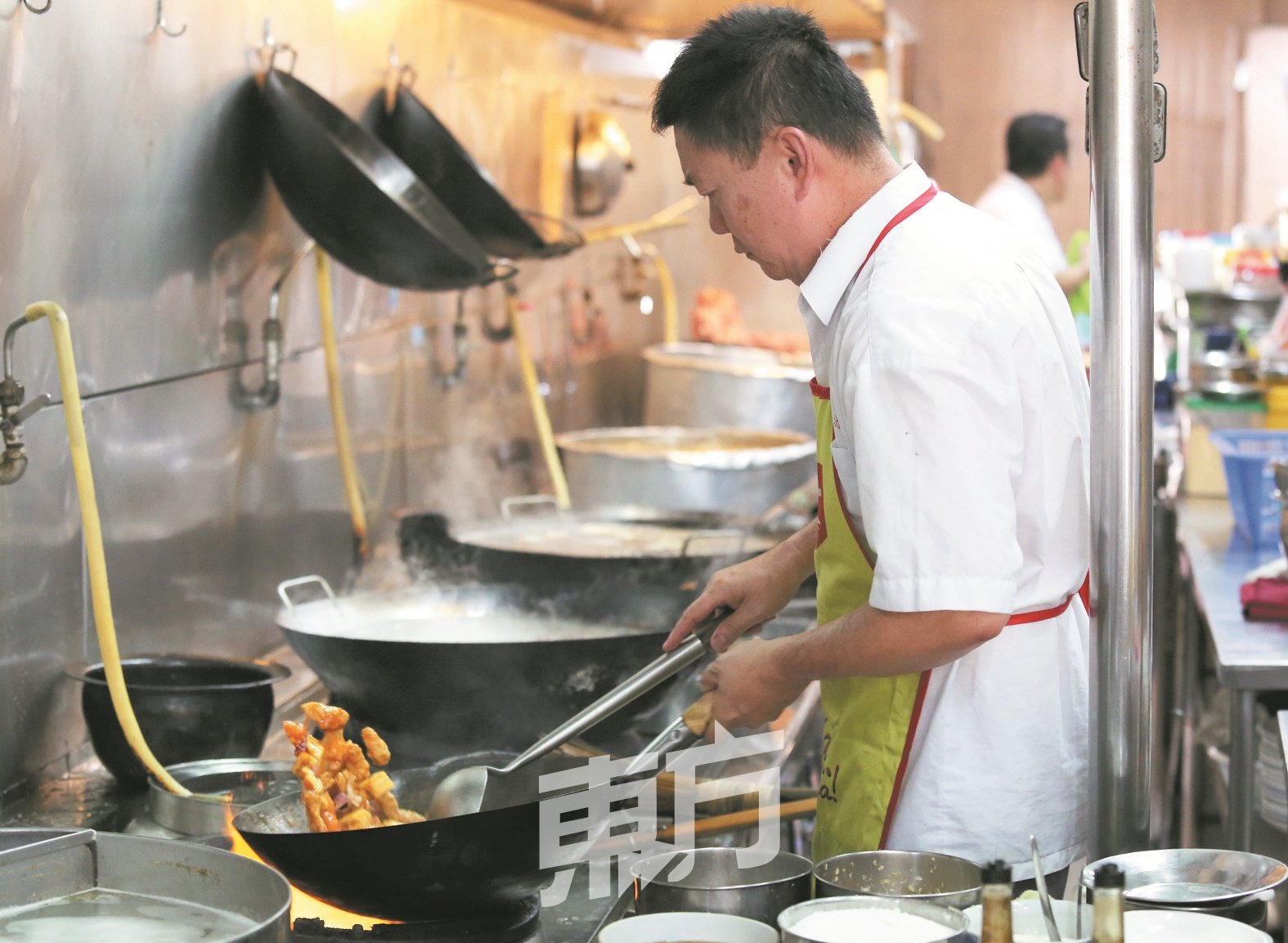古来新国泰冷气酒家厨师庄志松为黄扬球一家准备佳肴。