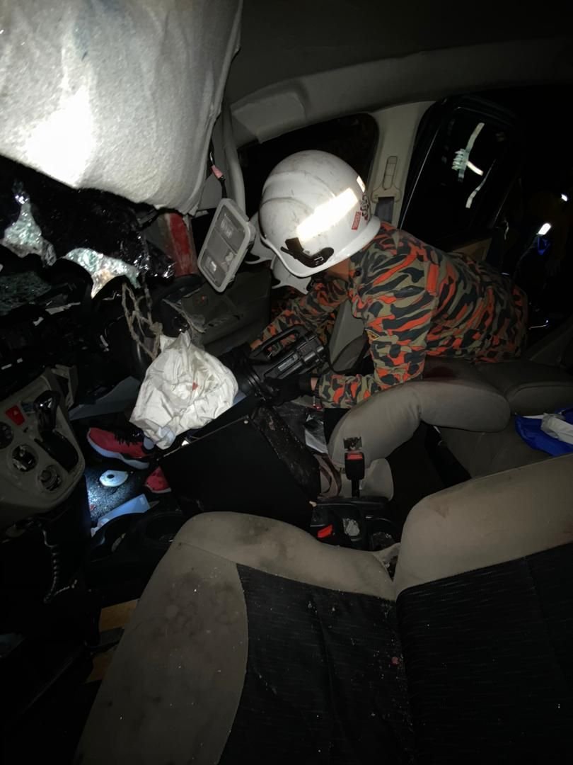 消拯员使用特殊工具，将夹在车内的死伤者移出车外。