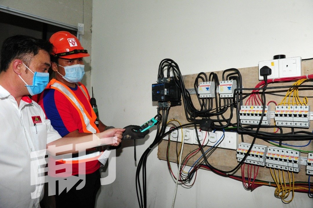 张健峰（左起）与国能职员随著业主进入商业单位，检查疑被动过手脚的电源设备。