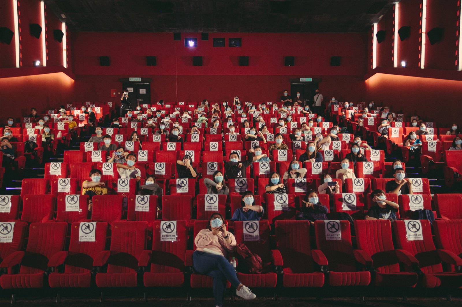 媒体和观众在戏院遵守社交距离下参与首映礼活动。
