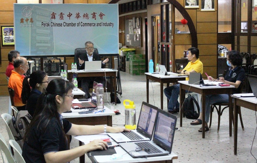 刘瑞裕（中）与数名理事及工作人员聚集在霹中总会所主持会议，其余的上百名会员及代表则在远程连线参与。