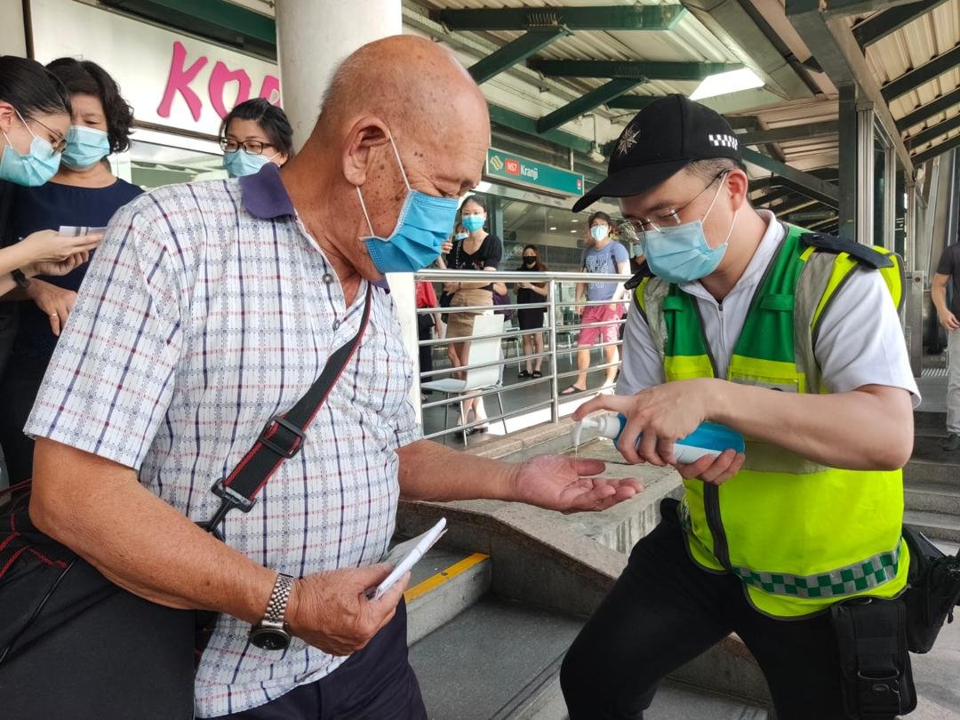 新加坡圣约翰救伤队为长者提供洁手液，让他们搓手消毒。