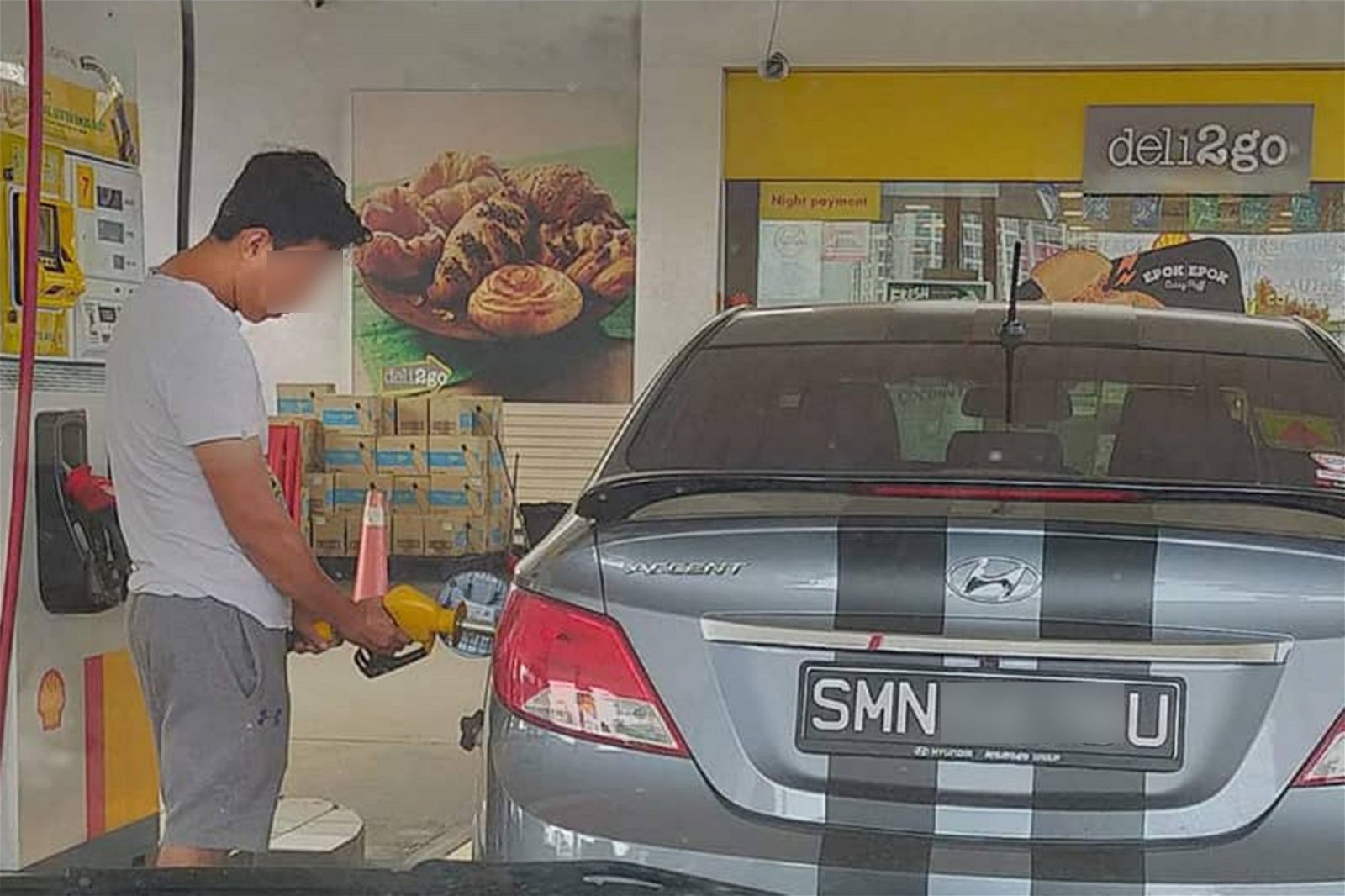 一名男子将RON95汽油的黄色油枪插入新加坡注册车辆添油，被后方车辆内的车主拍下照片放上社交媒体讨伐。 （图取自社交媒体）