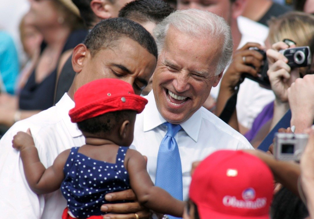 拜登作风亲民且容易和周围打成一片，这是他在2008年和美国前总统奥巴马，在竞选拉票途中逗小孩欢笑。（路透社）
