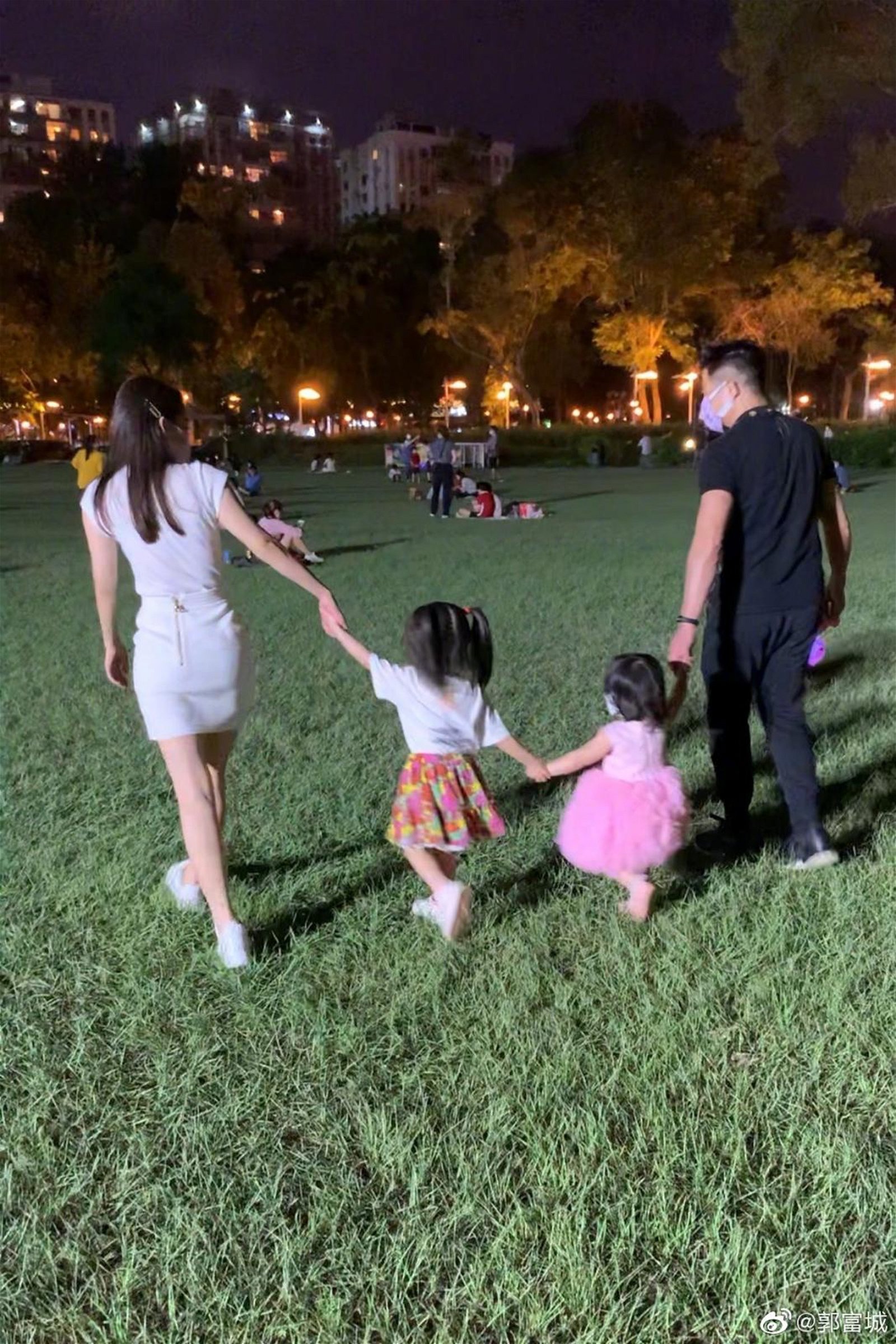 郭富城和太太方媛带著一对女儿在公园赏月。