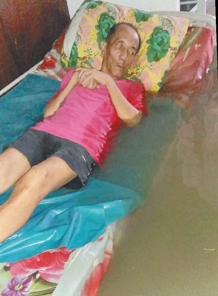 P南利路养老院处于严重水灾区，在水灾发生时，行动不便的阿伯躺在床架上，眼睁睁看著雨水逐渐把其背后浸湿了，手足无措。（档案照）