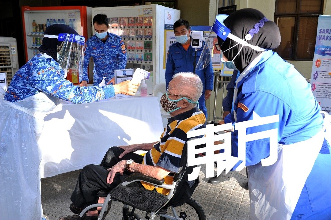 尽管一些乐龄人士行动不便，但依旧坐轮椅赴约接受疫苗接种。