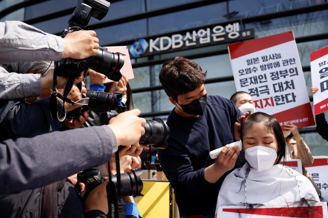 韩国女大学生在日本驻首尔大使馆前削发，表达不满。（图取自路透社）