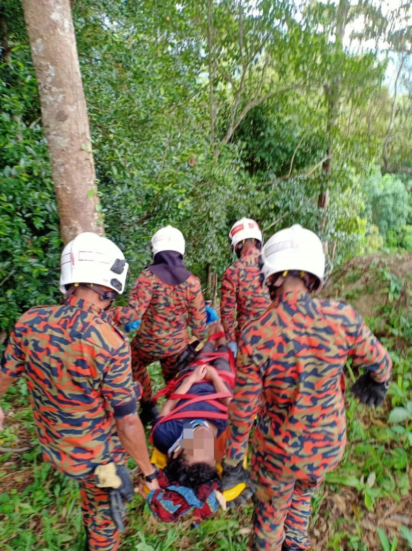 消拯员用担架把伤者抬下山，送往医院治疗。