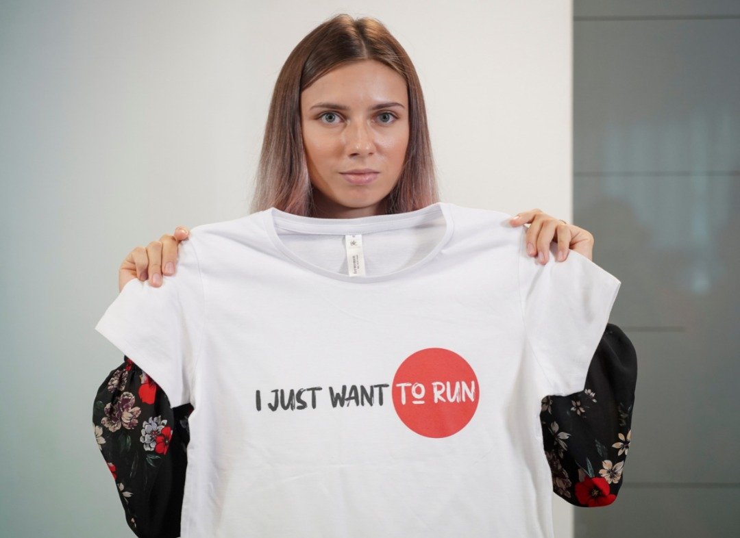 已抵达波兰首都华沙的白罗斯女子短跑运动员齐马努斯卡娅表示，希望能留在波兰继续运动员生涯。她在记者上展示一件写着“我只是想要赛跑”标语的衣服。（图取自路透社）