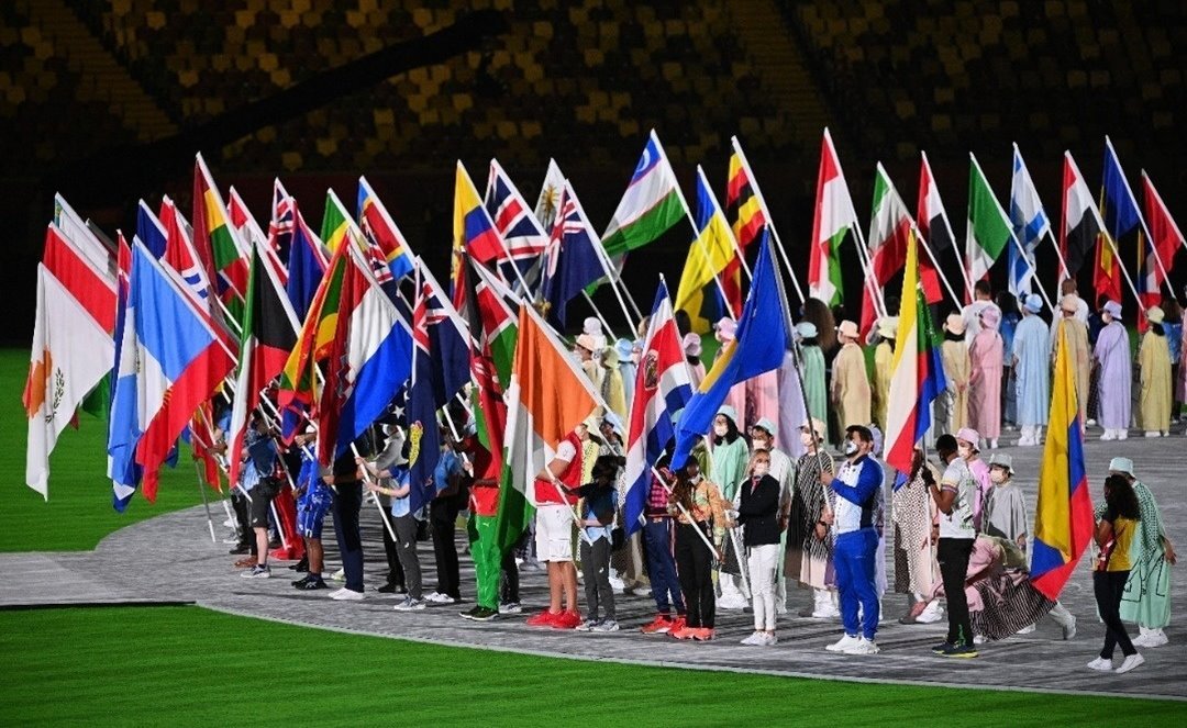 举着国旗的运动员，齐聚在场馆中央。（图取自法新社）