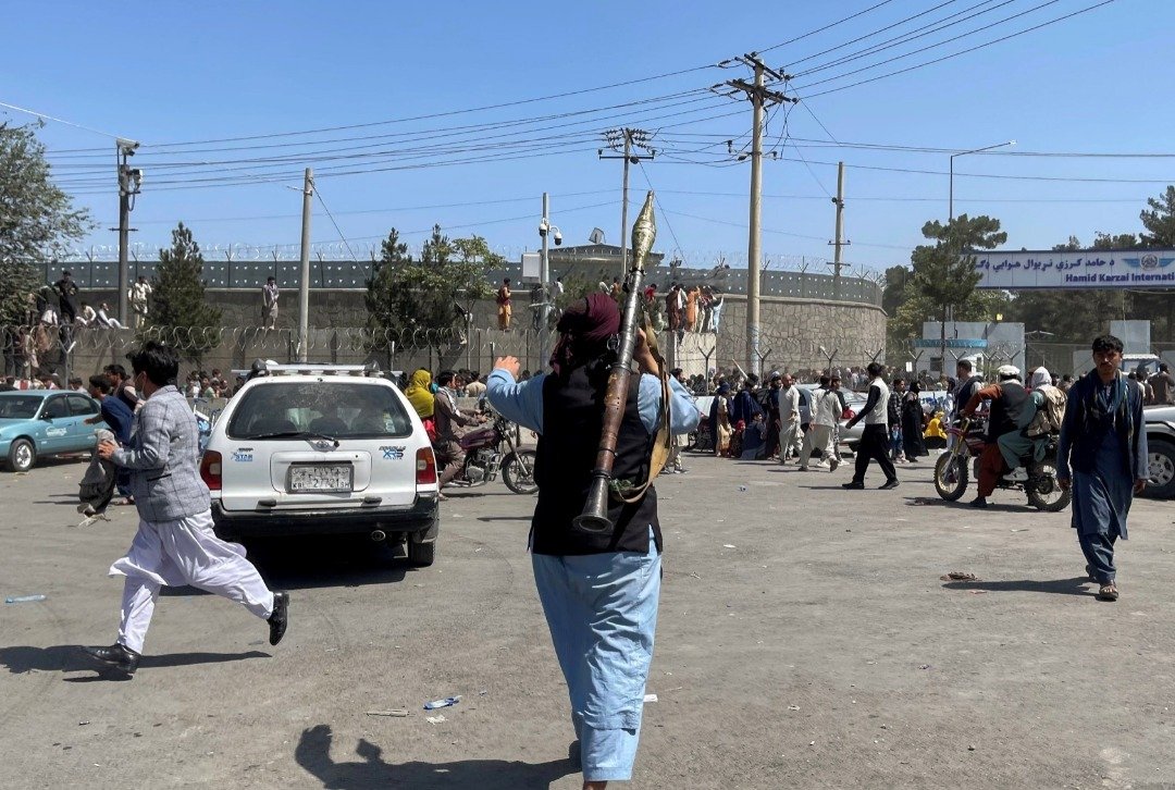 阿富汗武装组织塔利班的成员，周一在喀布尔国际机场外检查周围情况。（图取自路透社）