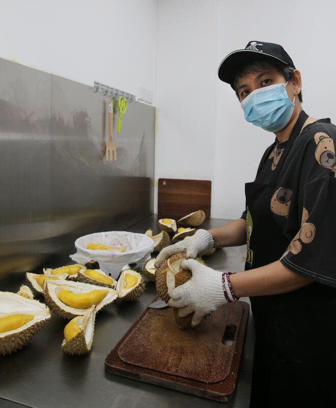 六姐弟妹各司其职，大姐郭文娟负责在店内开榴梿装盒。