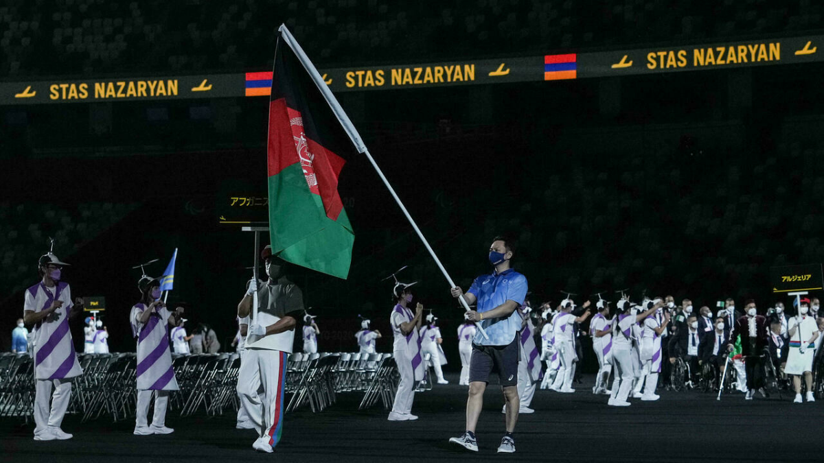 阿富汗国旗由一名志愿者担任旗手，出现在周二的开幕式上。（图取自法新社）