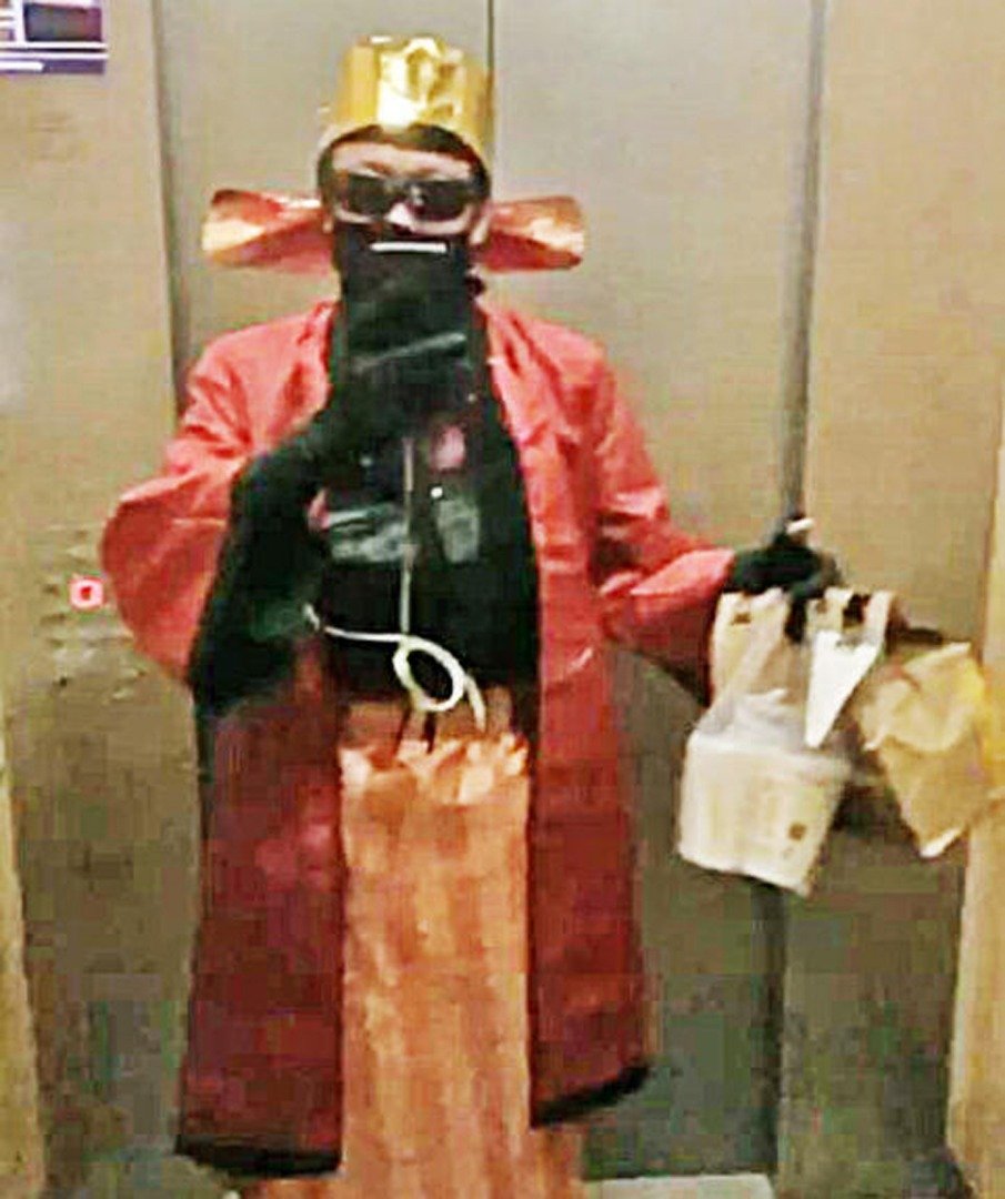 奥发扮演的财神爷提著外卖，搭电梯准备送餐。（受访者提供）