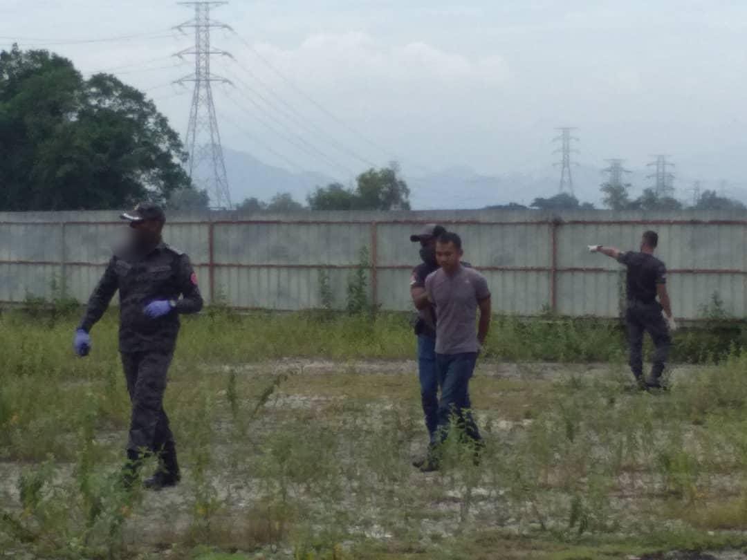 企图爬越锌板围篱逃走的外籍员工，最终被执法人员逮捕。（移民局照片）