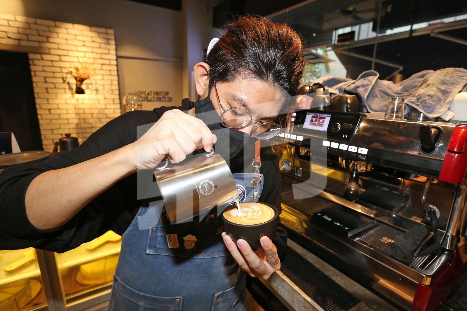 王义琥在咖啡吧台制作咖啡拉花。（摄影：刘维杰）