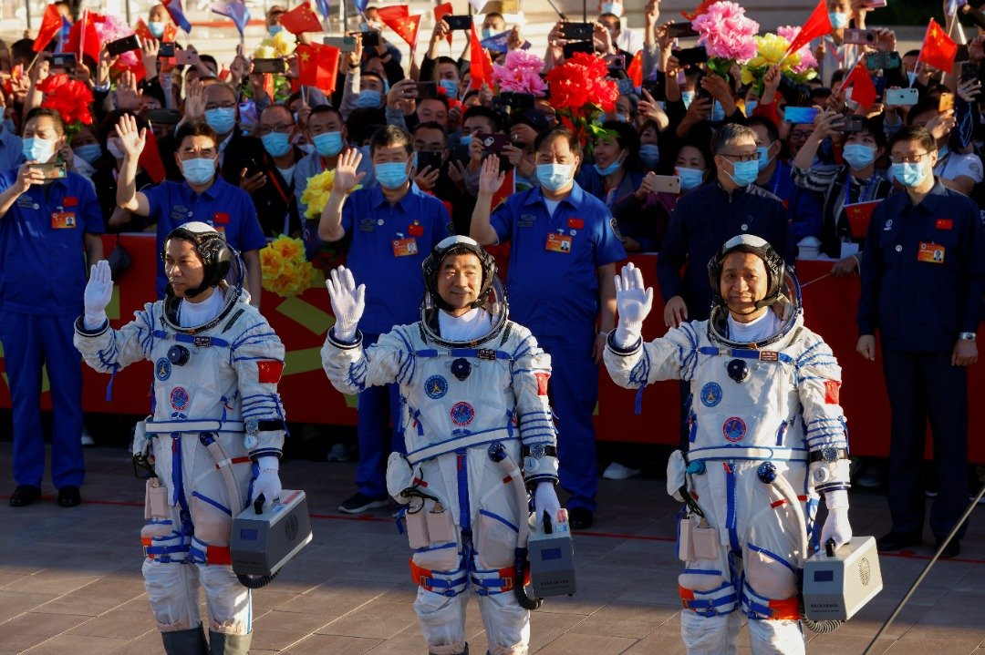 神舟十二号载人飞行任务的3名太空人，在酒泉卫星发射中心举行的出征仪式中，接受众人的祝福和鼓励。（图取自路透社）