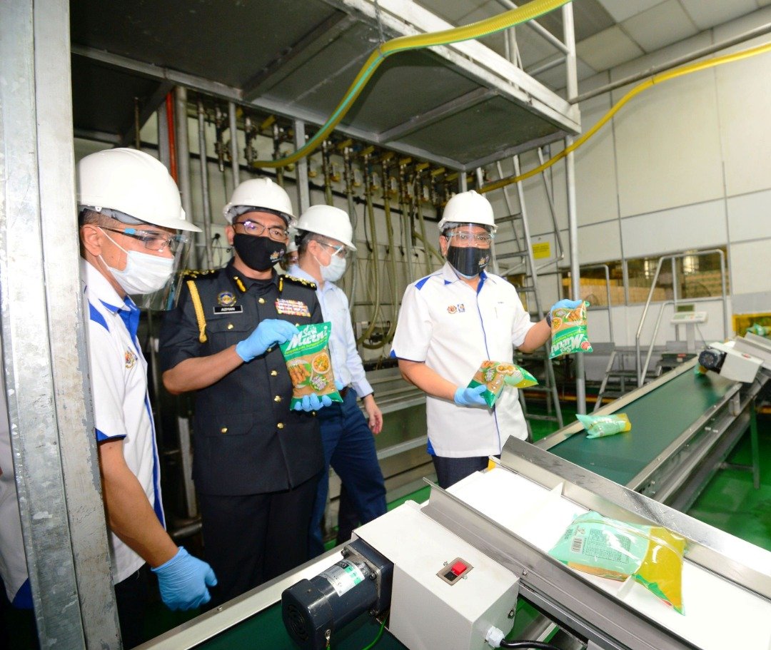 哈斯诺（左4）周日到巴西古当工业区一间津贴食油包装厂巡视津贴食油包装程序。左2为阿兹曼。 （照片由贸消部提供）