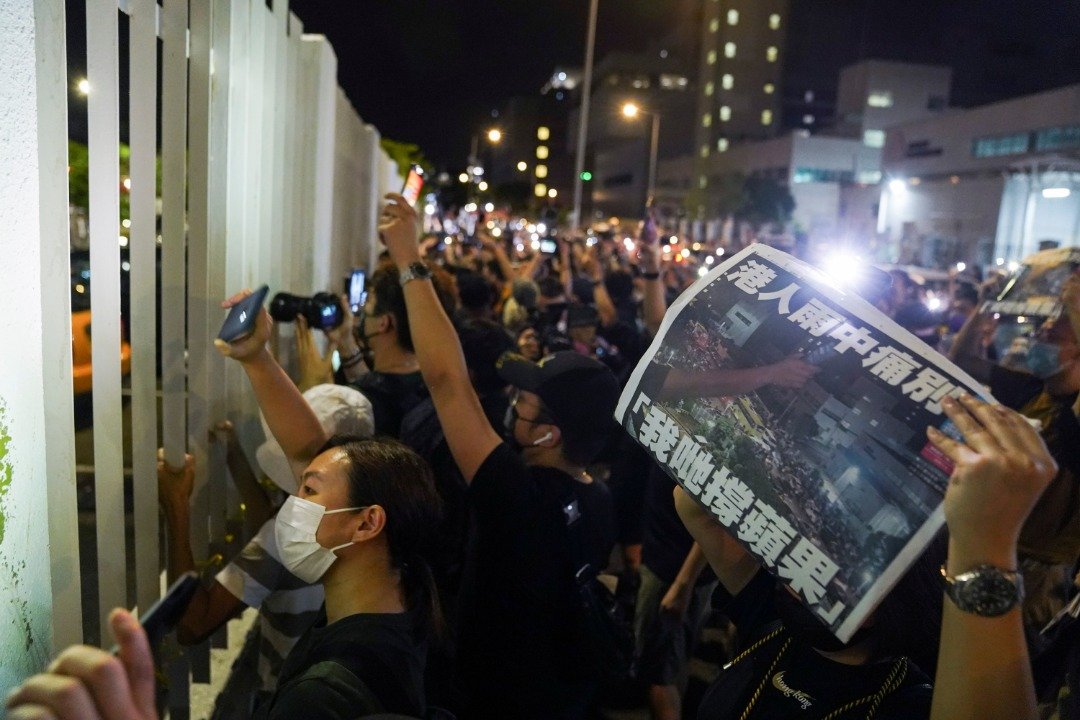 《苹果日报》出版最后一份报纸，大批支持者深夜在壹传媒大楼外聚集，向《苹果》员工致意。这是支持者在大闸外高叫口号，为留守到最后的员工打气。（图取自路透社）