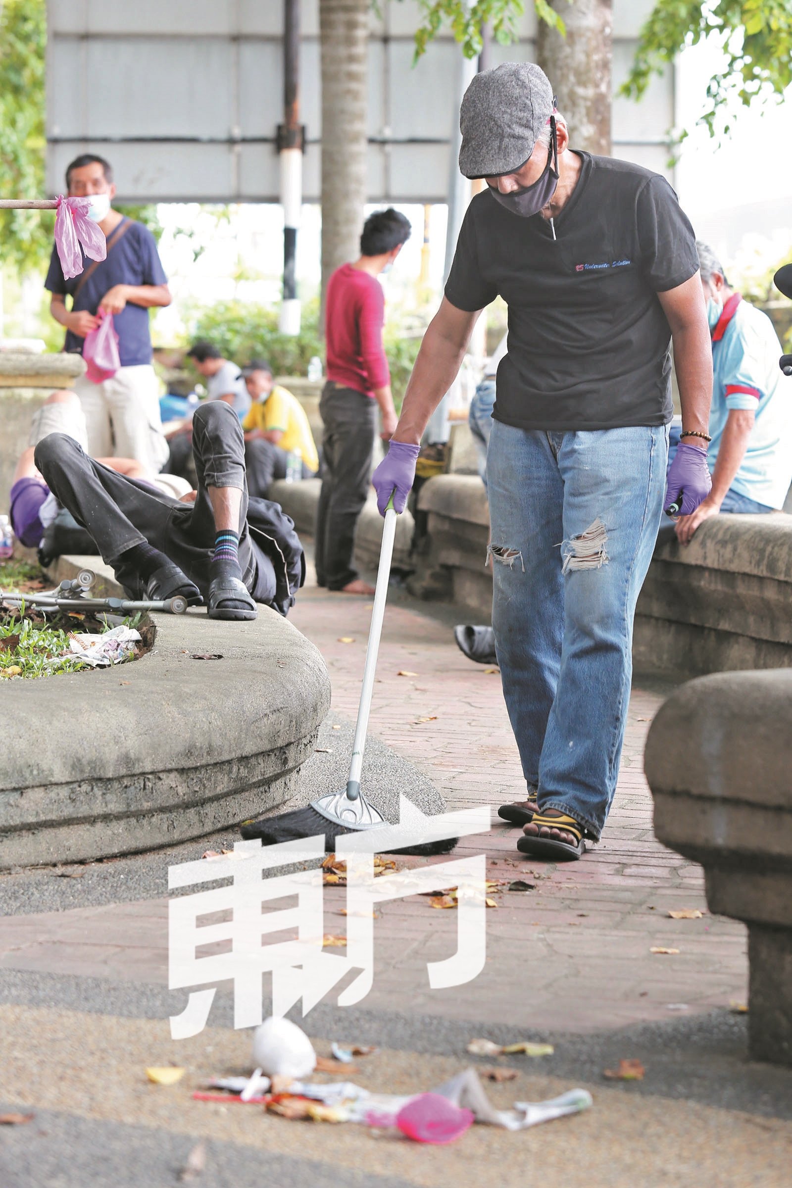 一名失业者在新山市区依布拉欣路的敦斯里拉囊广场生活，主动打扫周围卫生。