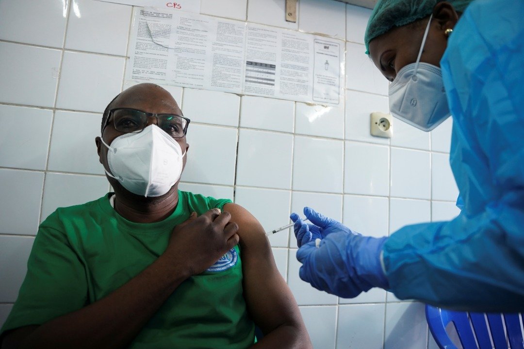 刚果（金）一名男子在首都金萨沙的一家诊所，接种阿斯利康（AstraZeneca）的新冠疫苗。（图取自路透社）