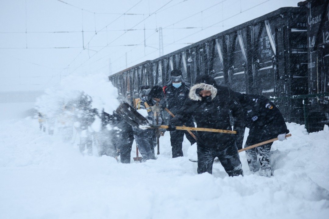 内蒙古赤峰市周二部分铁路路轨被积雪掩埋，当局动员1200多人清理，其后列车成功开出。（图取自法新社）