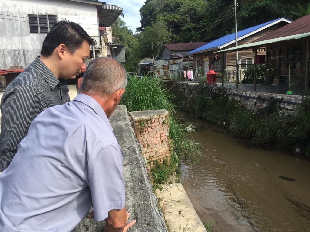张玉刚（左）早前在行动党碧兰璋新镇支部主席黄文源的陪同下，巡视闪电水灾的河段。