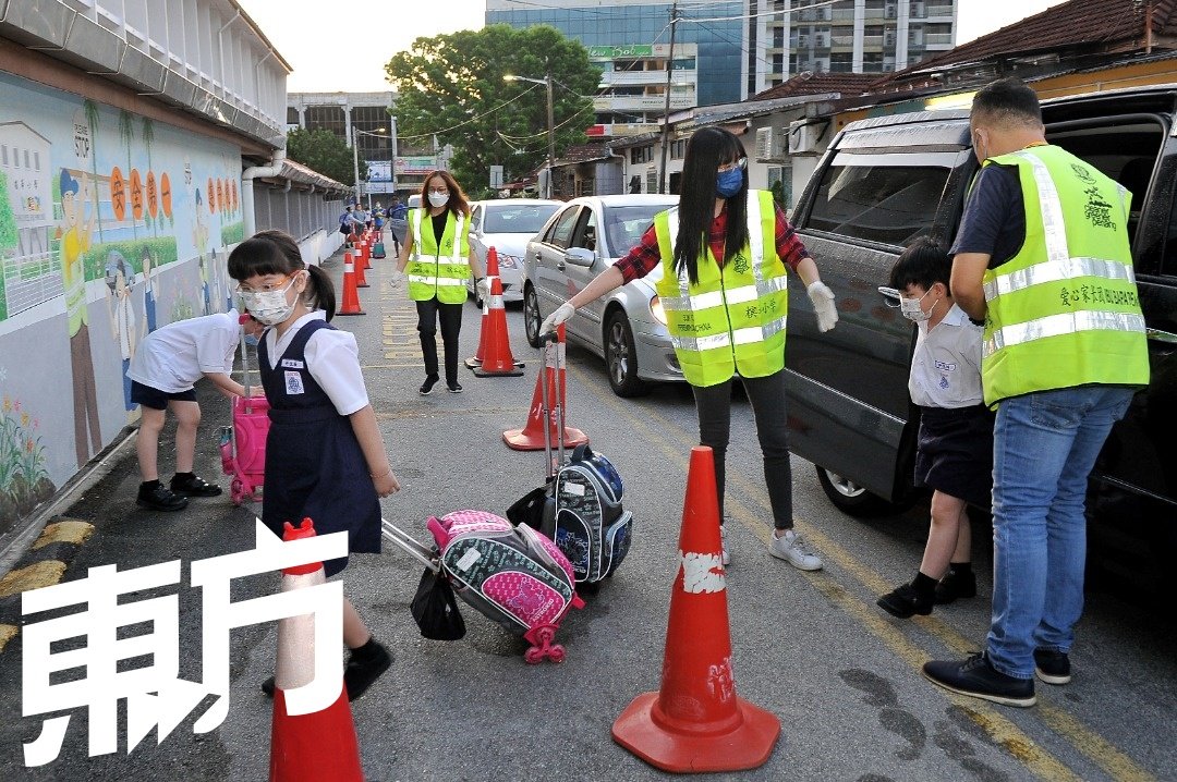 槟华小学爱心家长团交通组组员于周一早上抵达学校，协助校方维持校园外的交通秩序。