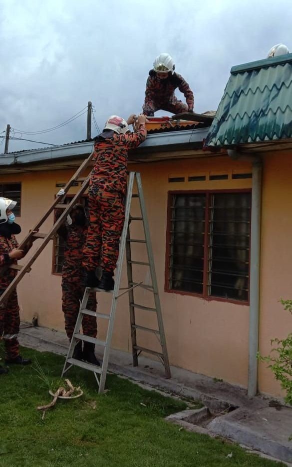消拯人员爬上屋顶，将昏倒死亡的老翁遗体移到地面。