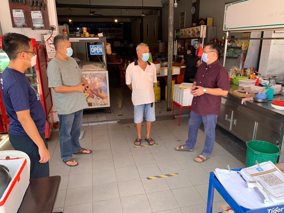 颜天禄（右）向鸡场街商家叶汉明（右2）说明市集恢复运作的计划，左起为陈炜建、蔡永泉。