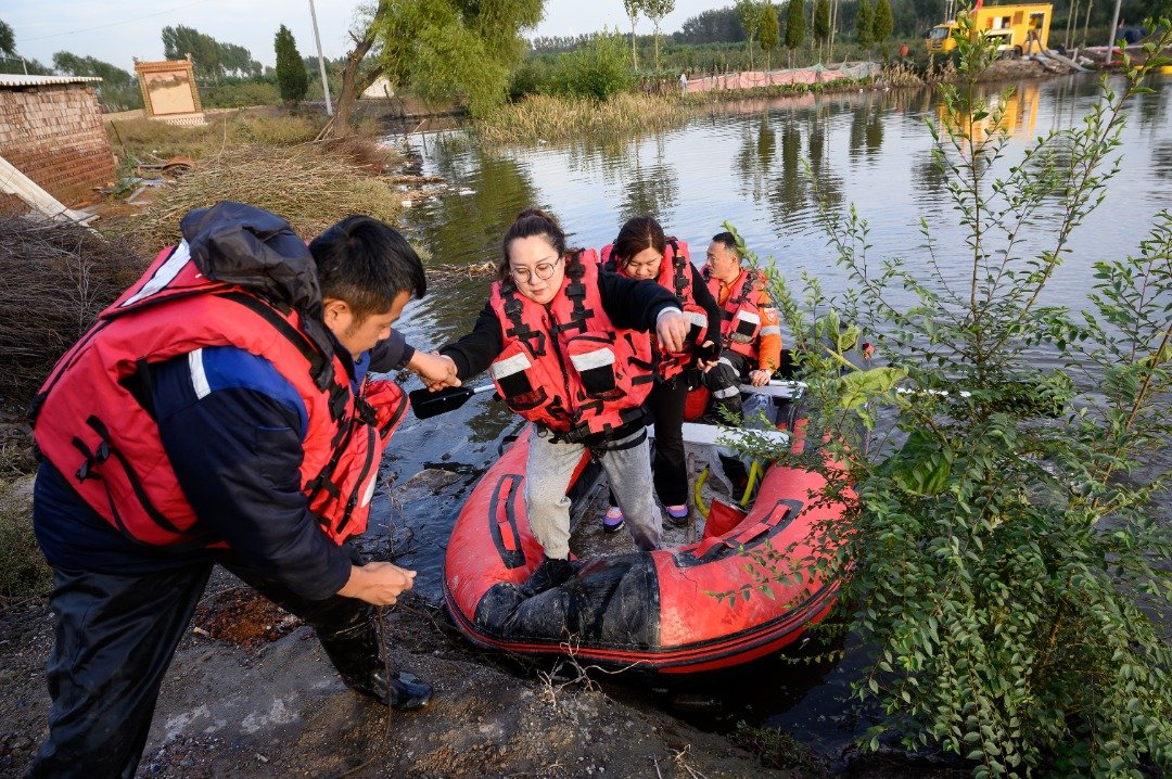 山西省介休市的汾河泛滥，洪水周日倒灌义安镇桑柳树村，救援人员将民众转移至安全地带。（图取自中新社）