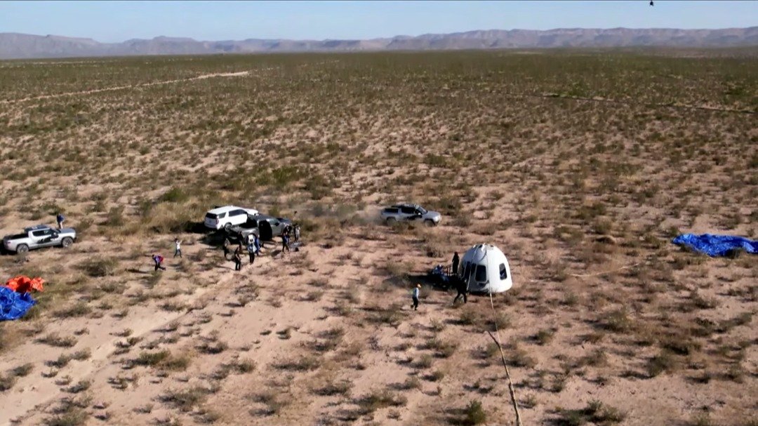 乘员舱通过降落伞，当地时间周三上午安全降落在得克萨斯州沙漠。（图取自路透社/蓝色起源提供）