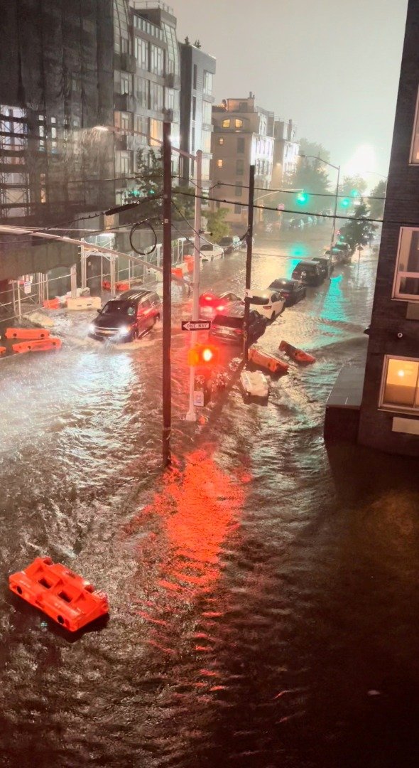 在纽约市布鲁克林区威廉斯堡，一辆汽车企图在遭洪水淹没的道路脱困。（图取自路透社）