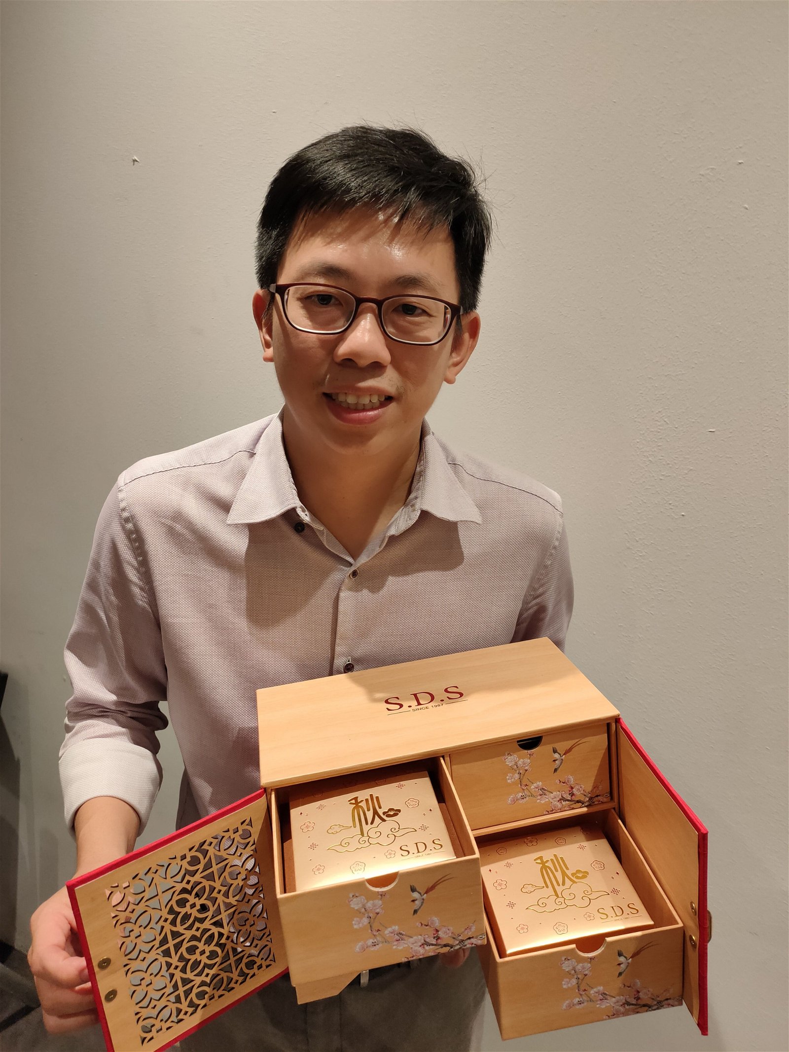 SDS新利香市场行销经理李凌升展示，该公司推出的其中一款月饼礼盒。受访者提供