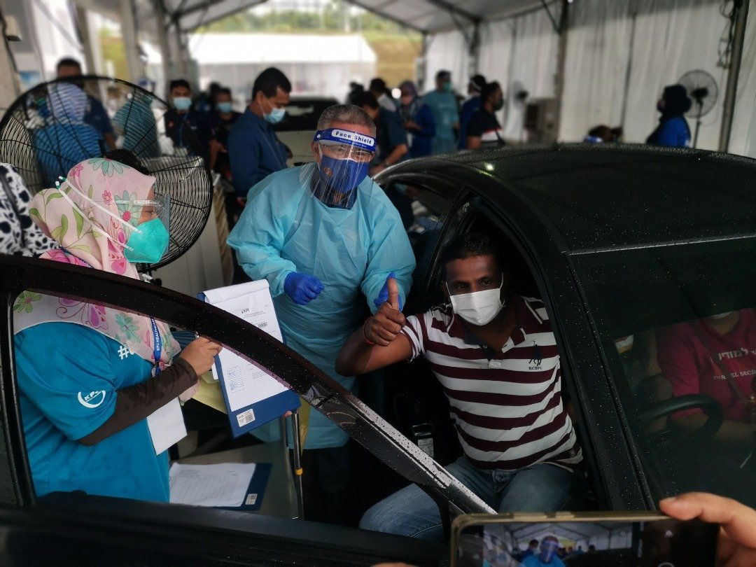 阿汉峇峇（中）在现场亲自为4名民众接种疫苗。