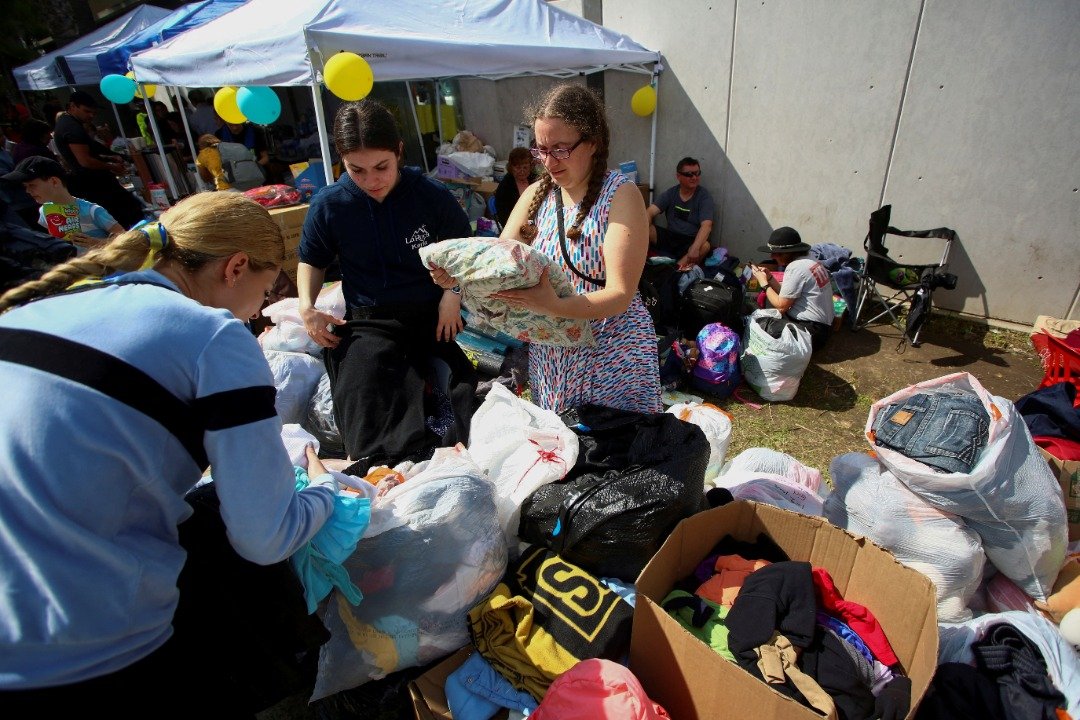 志愿者在蒂华纳，协助逃难的乌克兰人，挑选外界捐赠的衣物。（图取自路透社）