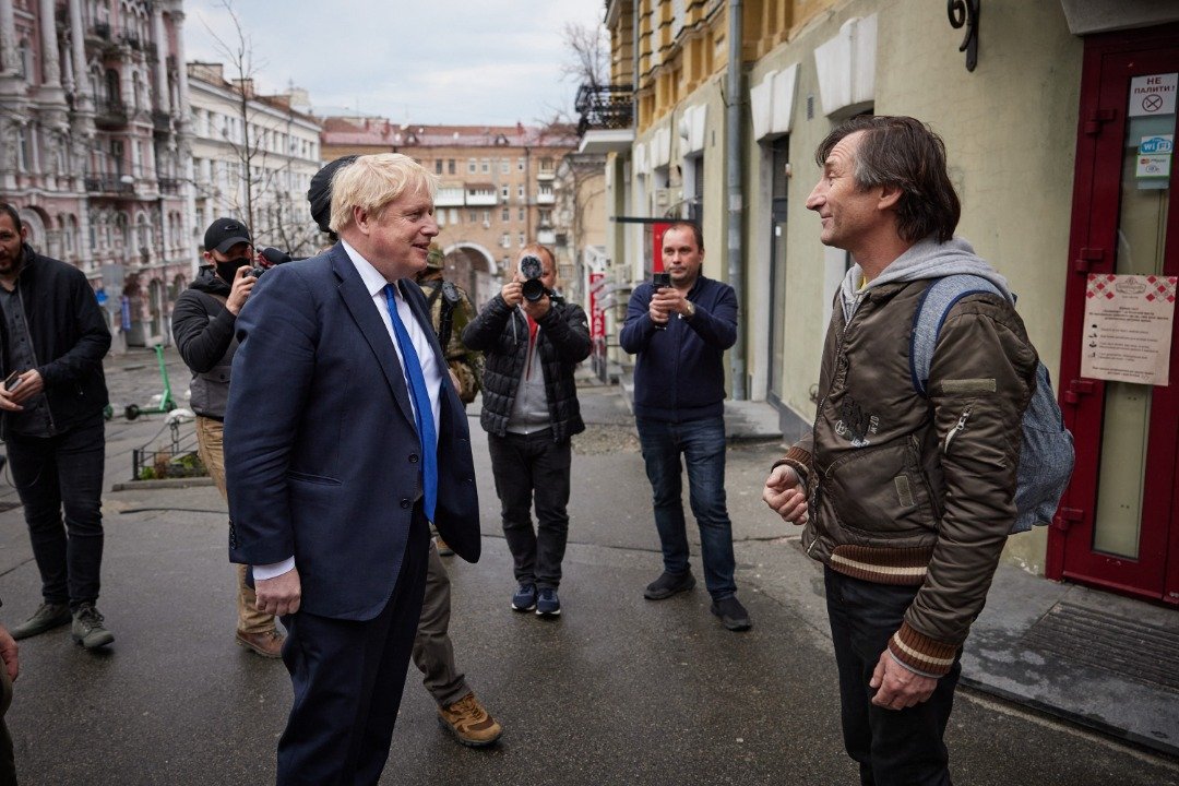 英国首相约翰逊（左）和一名基辅市民交谈。（图取自乌克兰总统新闻社/法新社）