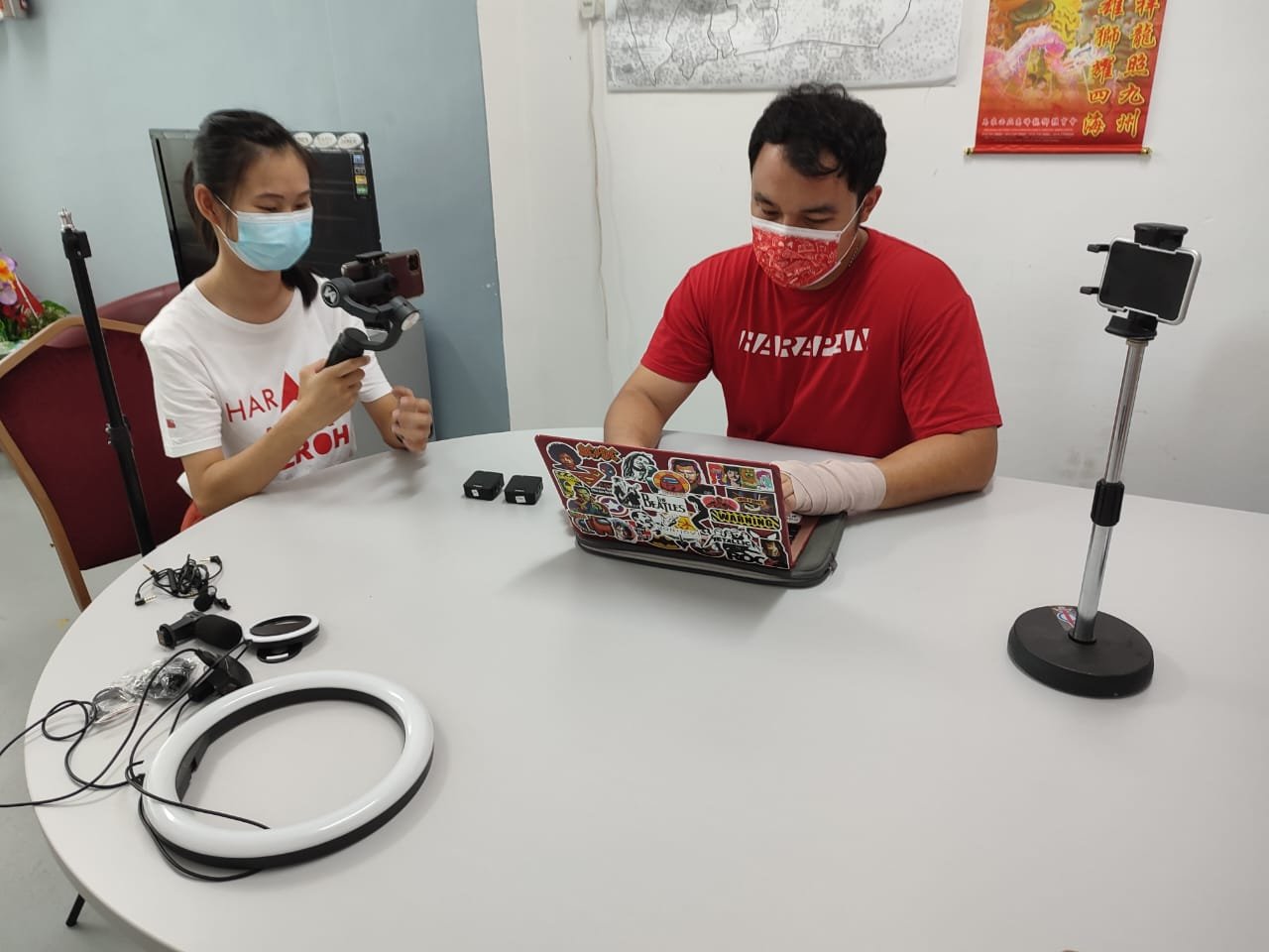 郭子毅（右）与负责管理其社交媒体的冯靖评讨论社媒文案内容，以及检查摄影器材。