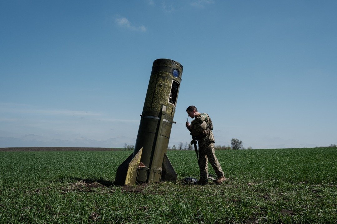 一名乌克兰军人当地时间周一看著一枚俄罗斯弹道导弹的助推器，该助推器级坠落于乌克兰东部博霍达罗夫的一片田地。（图取自法新社）