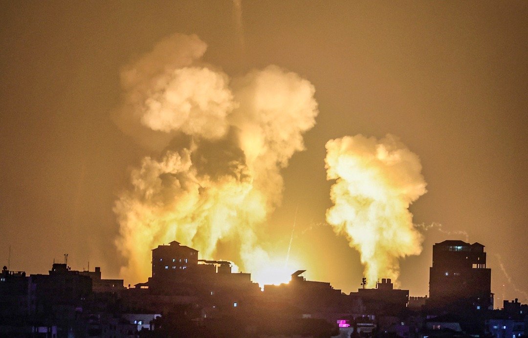 以色列对加沙的建筑物进行空袭后，楼房起火燃烧，冒起浓烟。（图取自法新社）